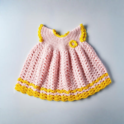 Baby-Strickkleid aus Baumwolle in Rosa mit gelben Details handgemacht Vorderseite mit Knopfverschluss und feiner Häkelstruktur
